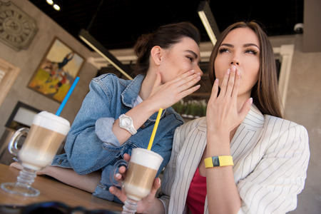 girl whispering to her friend