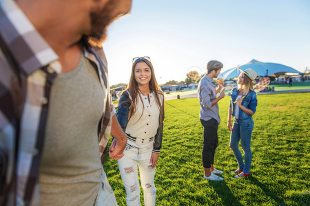 two couples standing on the grass against blue sky