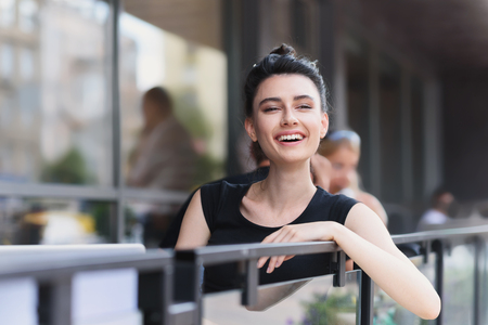 cheerful young woman laughing at the verandaの写真素材