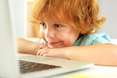 learning and next generation concept, adorable young kid smiling in front of pc