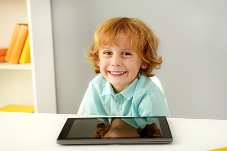 learning and next generation concept, intelligent young boy smiling in front of portable computerの写真素材