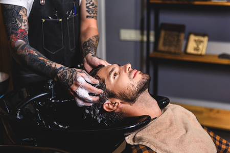man washing head with help of hairdresser, haircare conceptの写真素材