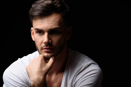 confident man sitting in a darkness with copy spaceの写真素材