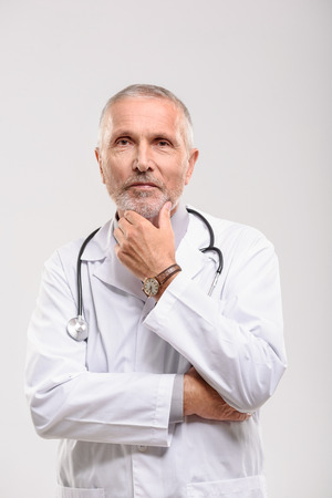 smiling doctor in uniform standing on white background, waist upの写真素材