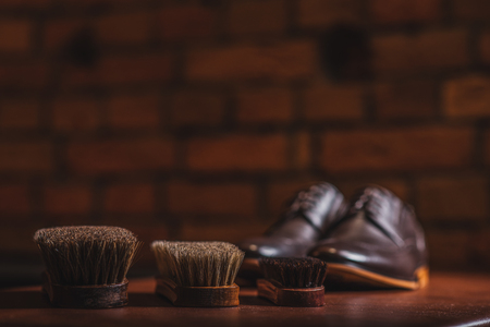 three brushes on the table with a pair of shoes on the table, selective focusの写真素材