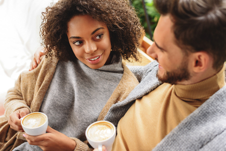 brunette talking with a guy while sitting in a cafeの写真素材