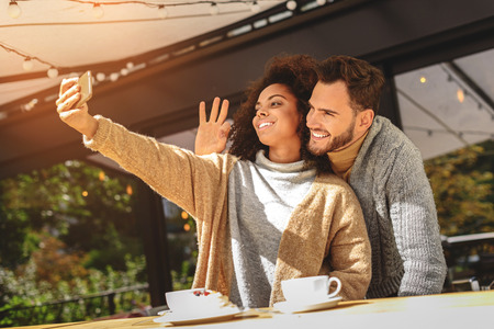 young woman taking a selfie of her with boyfriend on a terrace