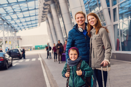 Organized and ready to go. Cropped shot of happy family standing outdoor near entrance of airport and waiting for taxi arrivalの写真素材