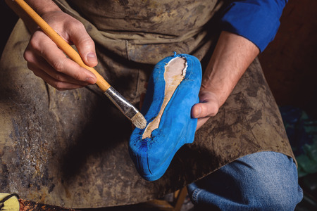 skin affixing to the sole of the shoe by a master, close upの写真素材