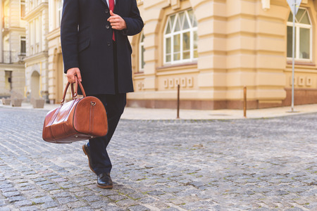 Rich man walking on street and carrying briefcaseの写真素材