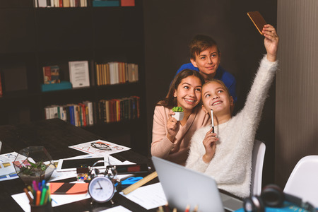 Happy teenagers are making collective photo. They are smiling with pleasureの写真素材