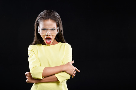 Young woman in sunglasses is shouting. She is isolated on background.の写真素材