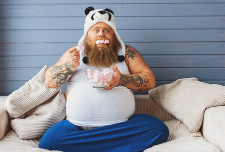 Greedy fat man eating sweet foodの写真素材