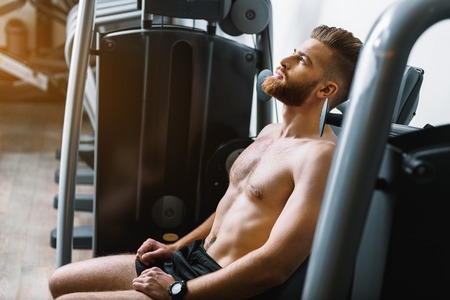 Tired sporty man in gymnasium