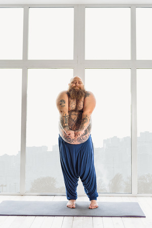 Fat man undergoing lazy workoutの写真素材