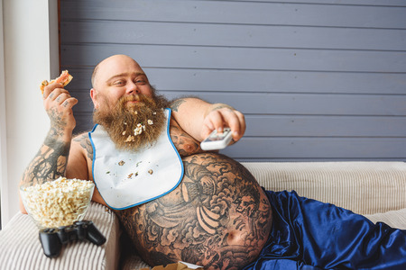 Lazy thick guy watching tv at home
