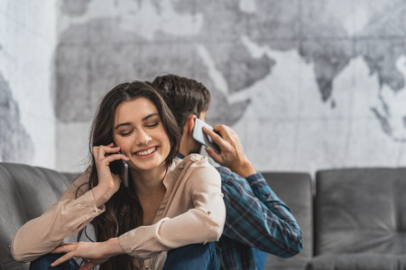 Modern couple using smartphones at home