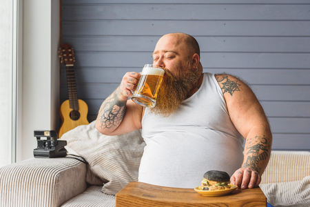 Thick guy drinking unhealthy beverageの写真素材