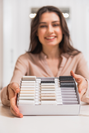 Confident shop assistant presenting objects for interiorの写真素材