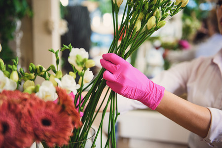 Cheerful woman making bouquet in shopの写真素材