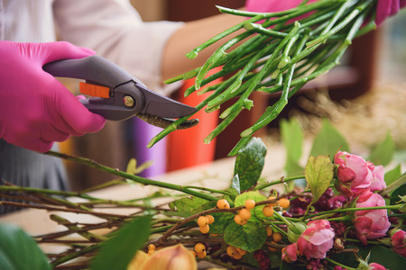 Skillful florist creating bouquet in storeの写真素材