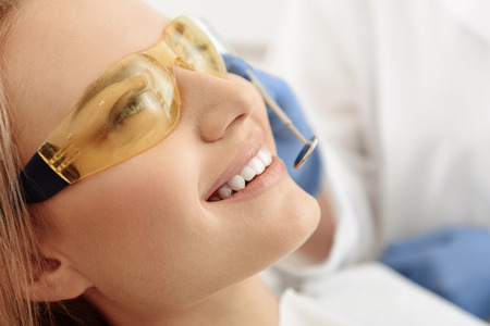 Happy patient treating oral cavity in dental roomの写真素材