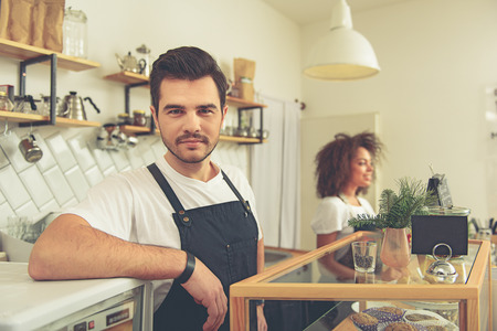Calm tapster trading pastry in cosy cafeの写真素材