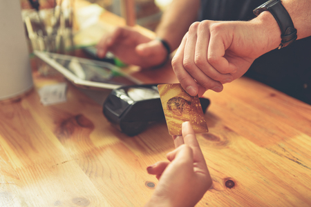 Barista making payment for service with terminal serverの写真素材