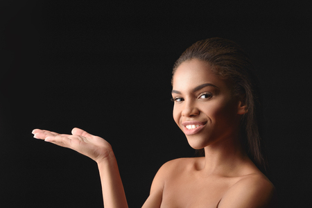Happy african woman showing something interestingの写真素材