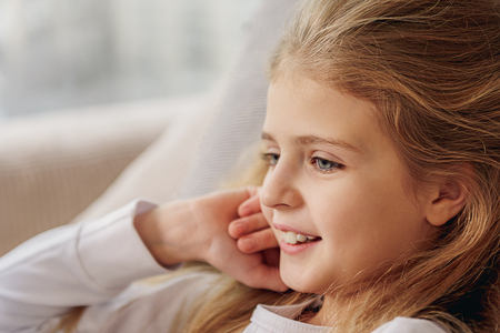 Happy kid lying on sofa at homeの写真素材