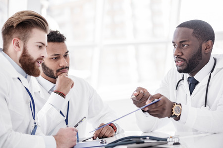 Calm doctors arguing during meeting in officeの写真素材