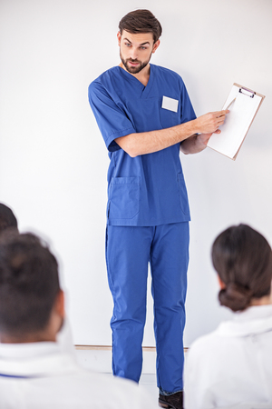 Calm medical adviser showing picture to partnersの写真素材