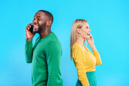 Happy man and woman communicating on smartphones