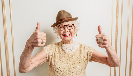 Cheerful old lady showing okay signの写真素材