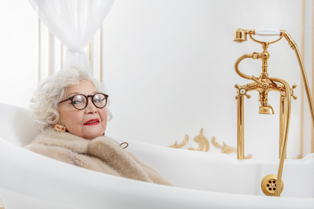 Wealthy senior lady relaxing in bathroomの写真素材