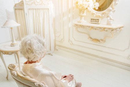 Senior lady relaxing on armchairの写真素材