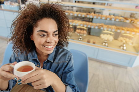 Brightly smiling girl resting in cafeの写真素材