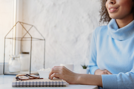 Cheerful girl is sitting near window. She having some restの写真素材