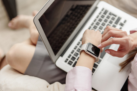 Woman looking at watch during workの写真素材