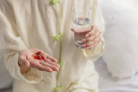 Female eating vitamins and drinking water