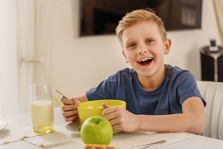 Happy kid having breakfast at homeの写真素材