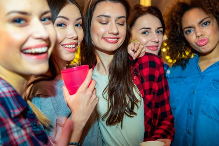 Happy young women mugging in roomの写真素材