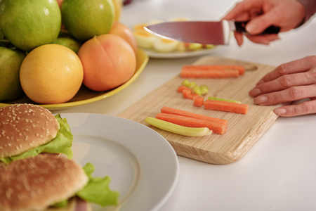 Skillful housewife cutting vegetables in kitchenの写真素材