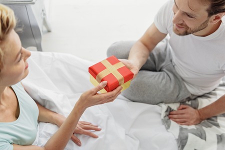 Cute married couple celebrating event at homeの写真素材