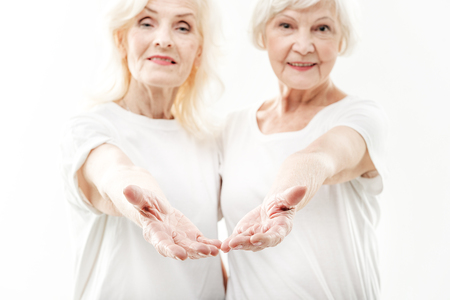 Excited mature ladies inviting someone by gestureの写真素材