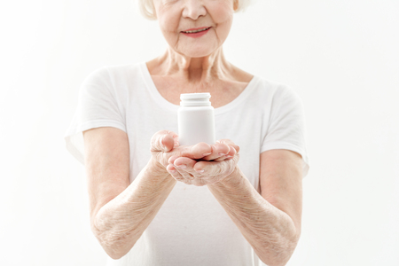 Cheerful mature woman presenting vitaminsの写真素材