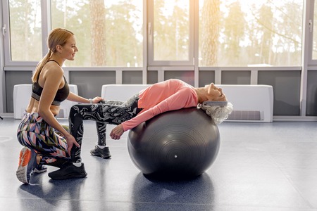 Outgoing retiree doing exercises on fitballの写真素材