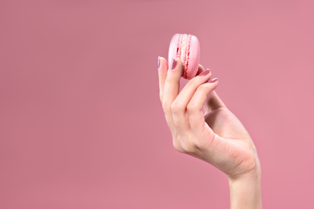 Tasty small cake in woman handの写真素材