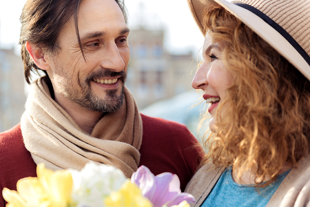 Joyful man giving bouquet to ladyの写真素材