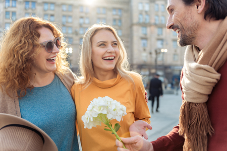 Happy father presenting bouquet to his familyの写真素材